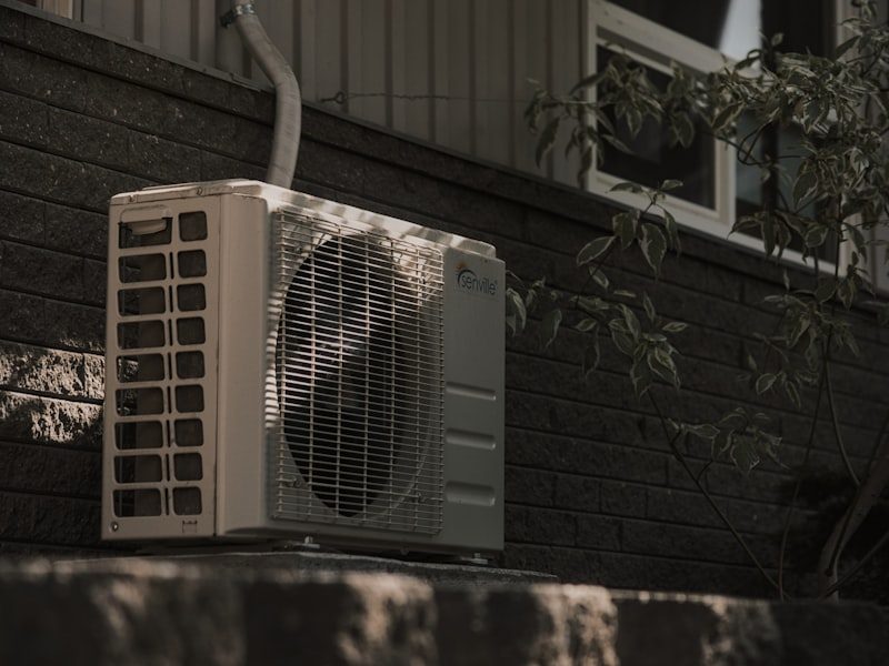 Air conditioner condenser unit mounted on an exterior wall
