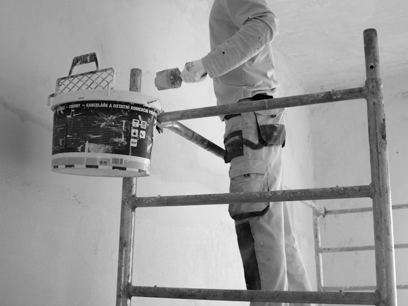 Painter on a scaffold painting an interior wall