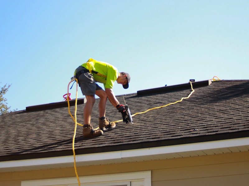 Roofer installing shingles on a residential roof